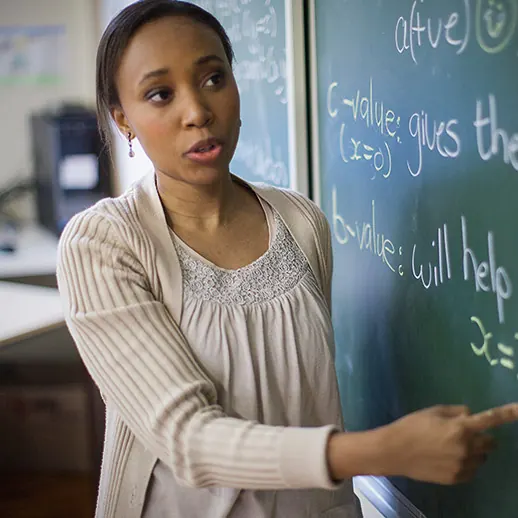 A teacher explaining a lesson at the chalkboard